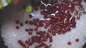 將炒好的食材和大米、紅豆一起放進(jìn)電飯鍋煮。