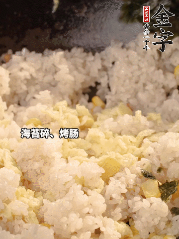 剩米飯下鍋炒散，依次下玉米粒、雞蛋、烤腸、海苔碎翻炒均勻。