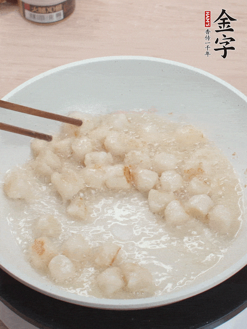 油溫4成熱，鮮貝蘸干淀粉下鍋煎，一面微黃后翻面。