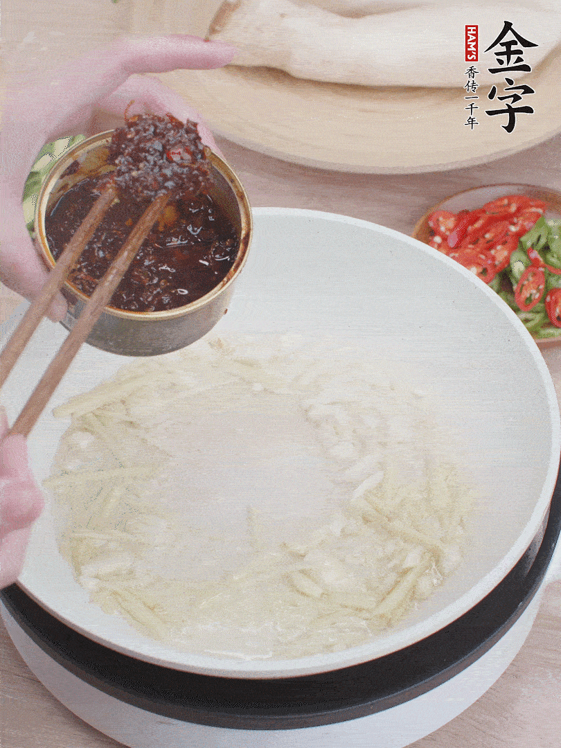 起鍋熱油，姜蒜、金字火腿干貝醬煸香。