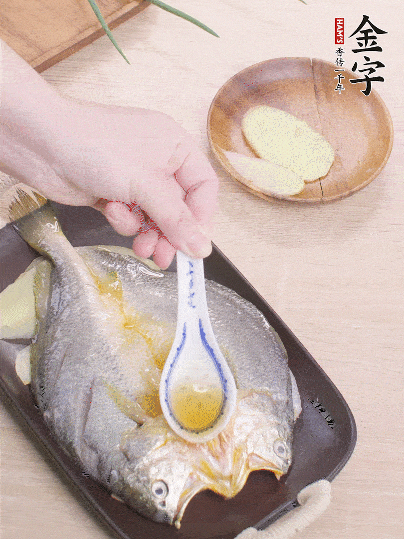 盤(pán)底鋪姜片，放黃魚(yú)，淋2勺料酒。